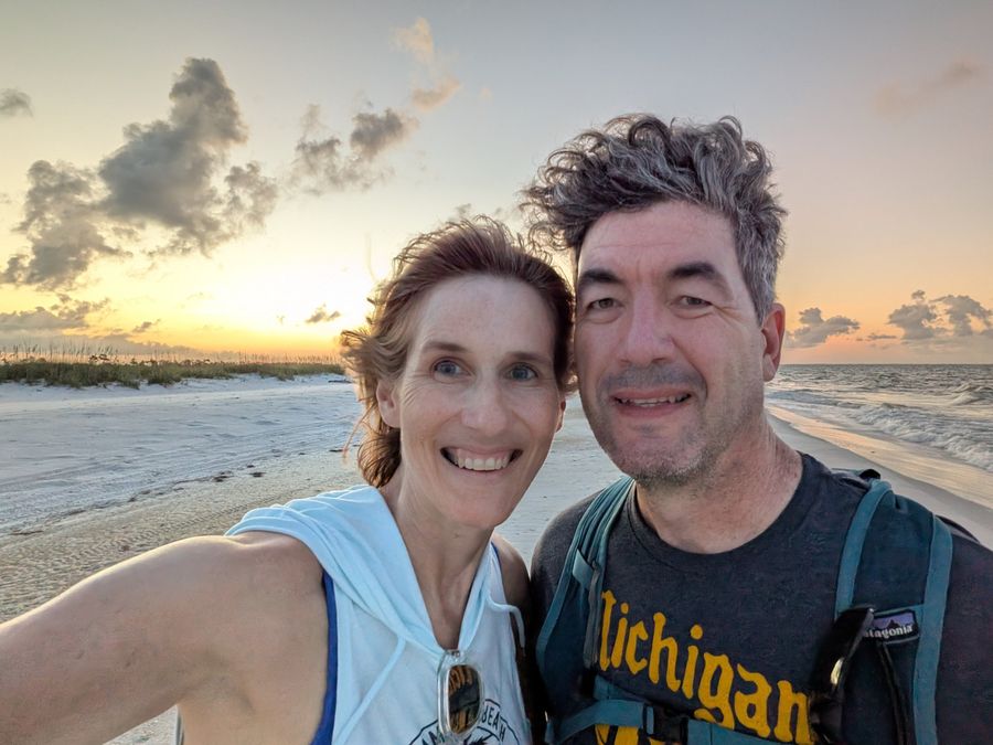 Ken and Lisa on the white sand at Crooked Island Beach in Panama City, Florida, packs on at dusk